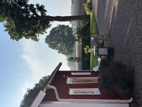 En röd byggnad med ett bord och stolar utanför